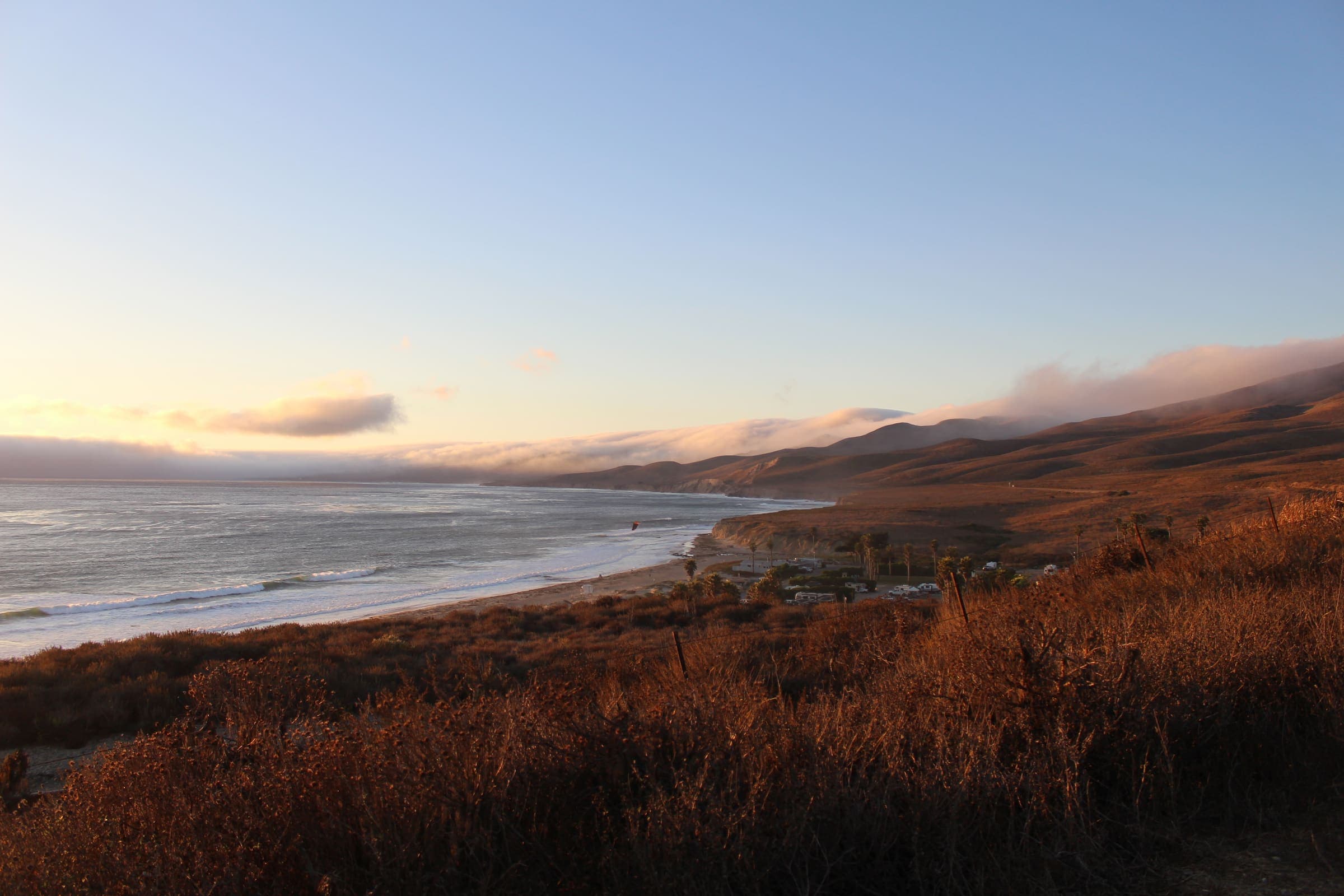 Golden hour view of a coastal hillside and beach