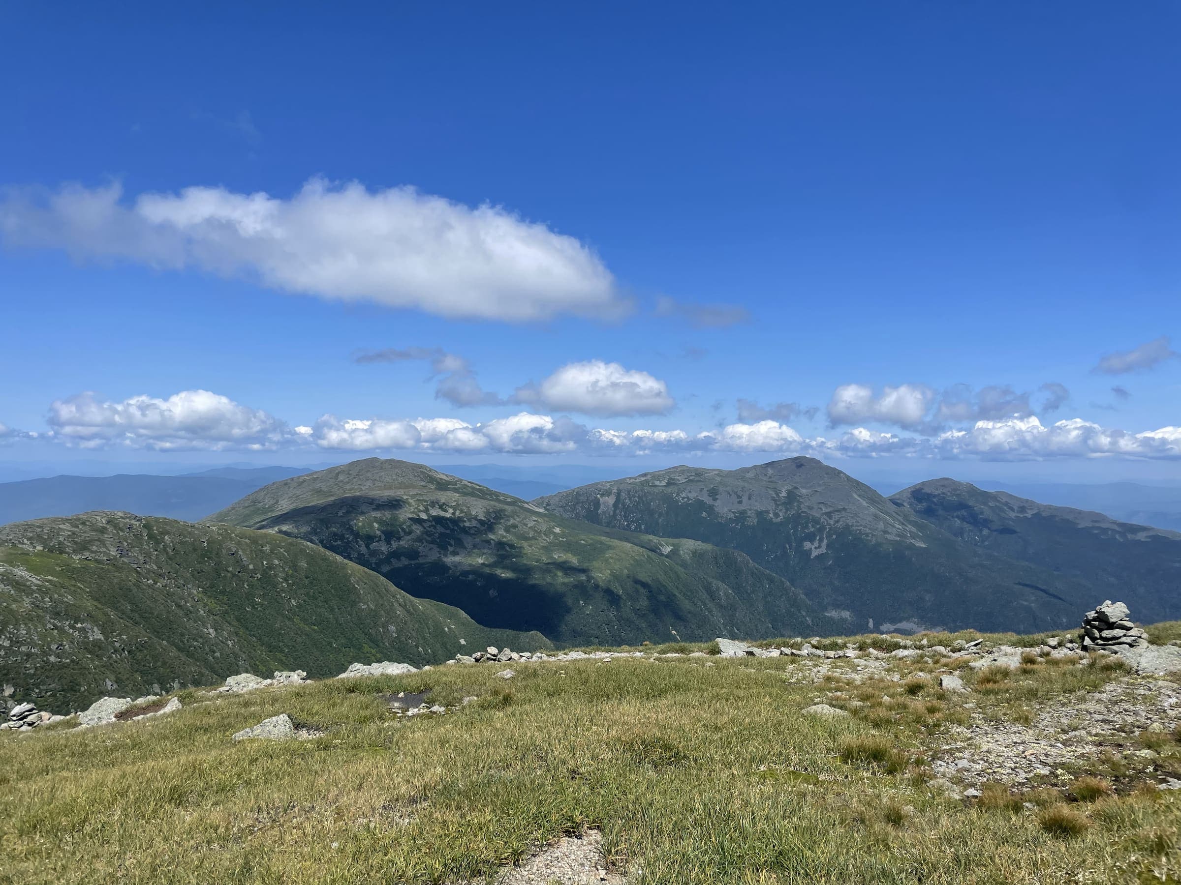 Trail cairn on a grassy mountain summit
